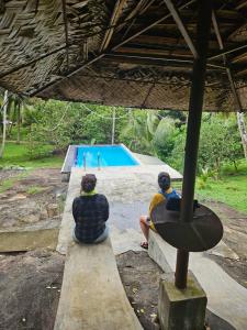 zwei Personen sitzen auf einer Bank und schauen auf einen Skatepark in der Unterkunft THE HIDEOUT KURUNEGALA in Kurunegala