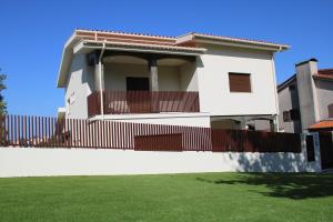a white house with a fence and a yard at ma-la studios Guimarães in Guimarães