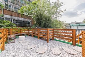 a patio with a wooden fence and benches at Luxury Hanok MOOD-AM in Seoul