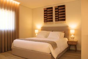 a bedroom with a large white bed and a window at ma-la studios Guimarães in Guimarães +91 photos