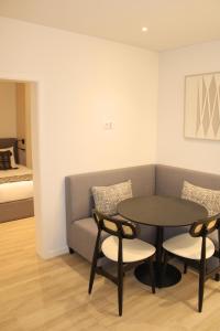 a living room with a table and a couch at ma-la studios Guimarães in Guimarães