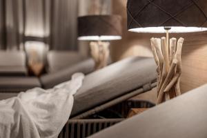 een woonkamer met een bank en een tafel met een lamp bij MYALPS Ötztal inklusive Spa- Area in Umhausen