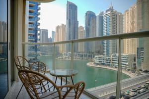 a balcony with a table and chairs and a view of a city at Khayali Marina Holiday Homes Dubai Marina JBR in Dubai