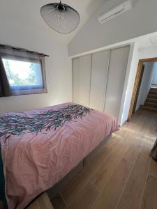 a bedroom with a pink bed and a window at Petite villa cocooning in Sisco