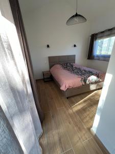a bedroom with a bed and a wooden floor at Petite villa cocooning in Sisco +19 photos