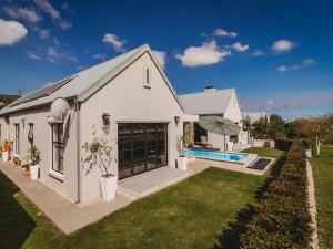 a white house with a pool and a yard at Moorlands Manor in George +88 photos