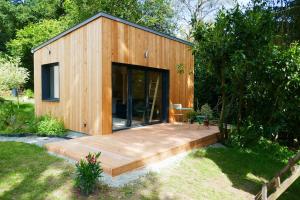 eine kleine Holzhütte mit einer Holzterrasse in der Unterkunft Studio bois indépendant aux portes de Nantes in La Chapelle-sur-Erdre