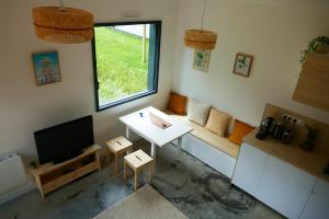 ein kleines Wohnzimmer mit einem TV und einem Tisch in der Unterkunft Studio bois indépendant aux portes de Nantes in La Chapelle-sur-Erdre
