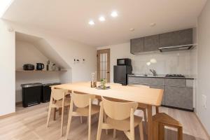 Una cocina con una gran mesa y sillas de madera. en 和船 wafune, en Tokio