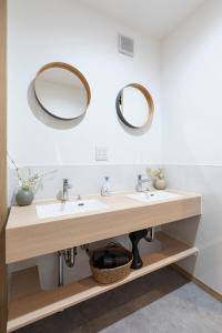 un baño con dos lavabos y dos espejos en 和船 wafune, en Tokio