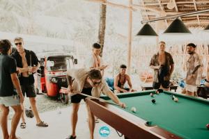eine Gruppe von Männern spielt Billard in einer Garage in der Unterkunft Chill Vibes Hiriketiya in Hiriketiya