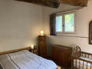 a bedroom with a bed and a window at Un Mazet en famille dans le jardin in Saint-Hippolyte-du-Fort
