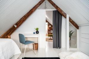 a bedroom with a bed and a desk and a chair at Hirsihuvi 1826 in Oulu