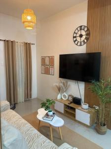 een woonkamer met een grote flatscreen-tv bij Cozy Three-Bedroom Staycation House with Netflix, Wi-Fi, and Free Parking Garage near SM Caloocan in Manilla