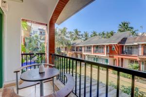 a balcony with a table and chairs and some buildings at Royale Holiday Villa - 4BHK JAQK Holidays in Baga