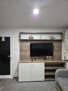 ein Wohnzimmer mit einem Flachbildfernseher an der Wand in der Unterkunft Lovely 4 Berth Caravan With Free Wi-Fi At Harts Holiday Park, Kent Ref 74108B in Leysdown-on-Sea