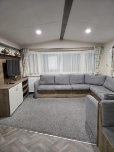 ein Wohnzimmer mit Sofa und Fernseher in der Unterkunft Lovely 4 Berth Caravan With Free Wi-Fi At Harts Holiday Park, Kent Ref 74108B in Leysdown-on-Sea + 5 Fotos