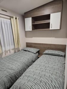 zwei nebeneinander stehende Betten in einem Schlafzimmer in der Unterkunft Lovely 4 Berth Caravan With Free Wi-Fi At Harts Holiday Park, Kent Ref 74108B in Leysdown-on-Sea