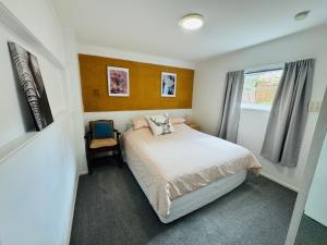 a small bedroom with a bed and a window at Delight at Golf in Auckland