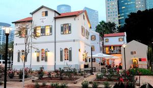 un bâtiment blanc avec un restaurant dans une ville dans l'établissement Grey Tel Aviv Center, à Tel Aviv