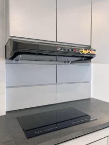 a stove top oven sitting on top of a kitchen counter at Luxury 3BR Podomoro Suite Medan City View NEW! in Medan +13 photos