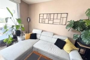 a living room with a couch and some plants at Le Beauvoir a chic haven near Strasbourg in Strasbourg