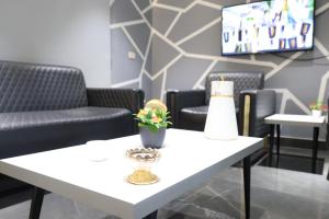 een wachtkamer met een witte tafel en stoelen bij ريلاكس للأجنحة الفندقية in Amman