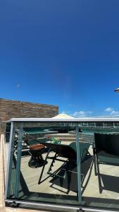 Un balcón con una mesa y sillas en un tejado. en Flat com Hidromassagem Privativa no Centro De Porto de Galinhas - Sol e Mar Residence, en Porto de Galinhas 25 fotos más