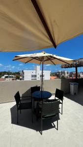 una mesa y sillas bajo una sombrilla en un techo en Flat com Hidromassagem Privativa no Centro De Porto de Galinhas - Sol e Mar Residence, en Porto de Galinhas