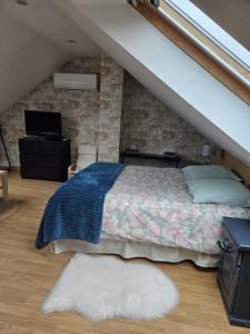 a bedroom with a bed and a stone wall at Chambre d'Hôtes à Magny le Hongre in Magny-le-Hongre