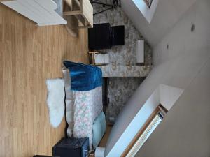 an attic room with a couch and a staircase at Chambre d'Hôtes à Magny le Hongre in Magny-le-Hongre