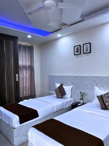 two beds in a hotel room with a blue ceiling at Cassava Stay in New Delhi +21 photos