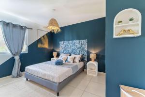 a blue bedroom with a bed and a blue wall at Tout est neuf dans ce beau Duplex pour 6 à 7p vue lagon in Marigot