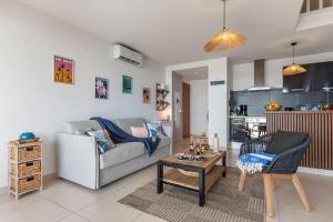 a living room with a couch and a table at Tout est neuf dans ce beau Duplex pour 6 à 7p vue lagon in Marigot