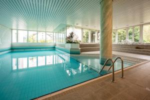 a swimming pool with blue tiles in a building at Casa Laret 6-12 in Laax-Murschetg