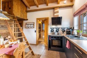 a kitchen with black appliances and a wooden ceiling at Chalet Bergliebe in Brilon