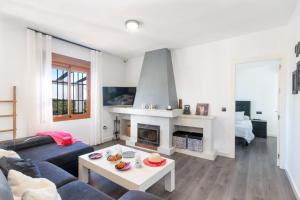 a living room with a couch and a fireplace at Villa Elisa in Nerja