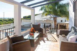a patio with chairs and a table on a balcony at Villa Elisa in Nerja