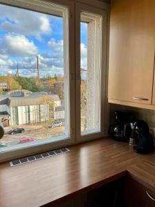 a kitchen window with a view of a city at City Bloom Apartment in Kotka