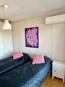 a bedroom with a blue bed and pink pillows at City Bloom Apartment in Kotka