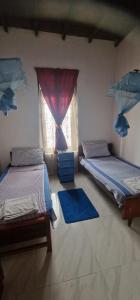 two beds in a room with a window at Perivale Budget Stay in Moratuwa