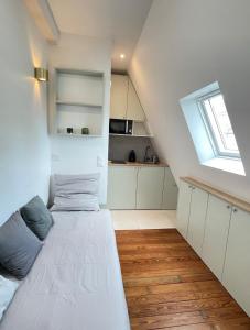 Una habitación blanca con una cama y una ventana. en Trocadéro - Studio 16, en París