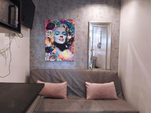 Una sala de estar con un sofá y un cuadro en la pared. en Trocadéro - Studio 16, en París