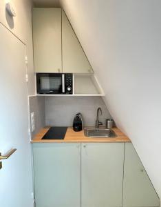 Una pequeña cocina con fregadero y microondas. en Trocadéro - Studio 16, en París
