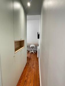 Un pasillo con armarios blancos y suelo de madera. en Trocadéro - Studio 16, en París