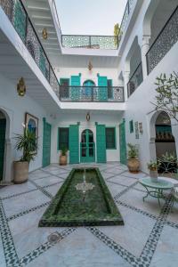 ein Innenhof mit einem Brunnen in der Mitte eines Gebäudes in der Unterkunft Riad Nejma Benyoussef in Marrakesch