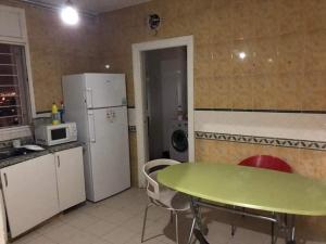 a kitchen with a green table and a refrigerator at Bardo centre in Tunis