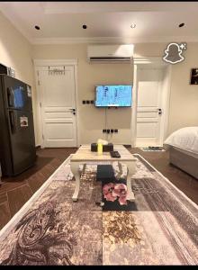 Una sala de estar con una mesa y un refrigerador. en شقة استديو VIp, en Yeda