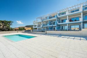 a large building with a swimming pool in front of it at AffittaSardegna - Bilo Elicriso in Trinità dʼAgultu