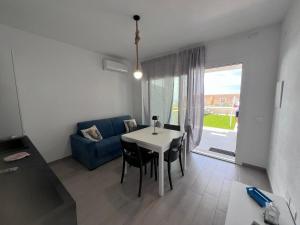 a living room with a table and a blue couch at AffittaSardegna - Bilo Elicriso in Trinità dʼAgultu +15 photos